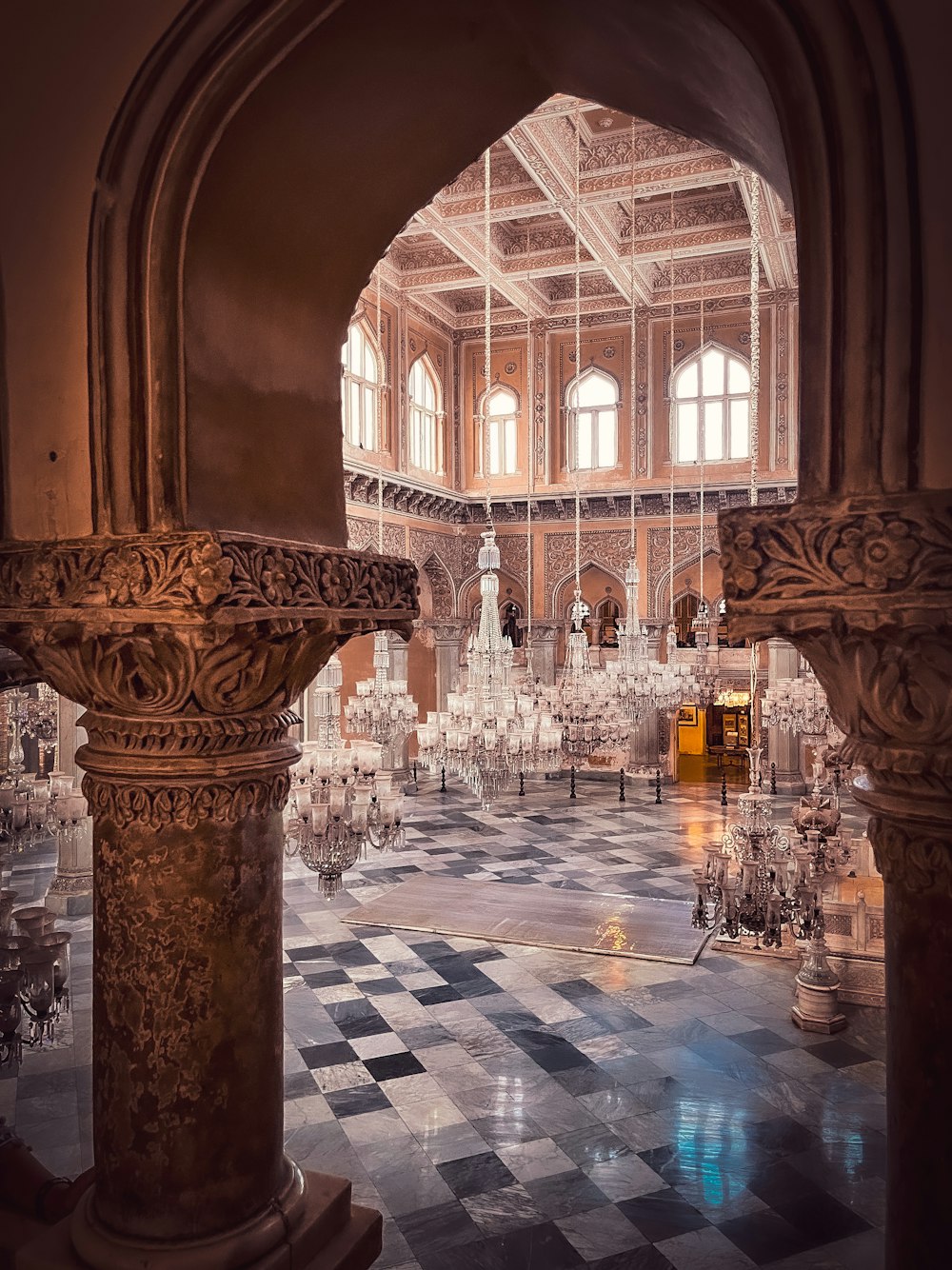 a large room with chandeliers and a checkered floor