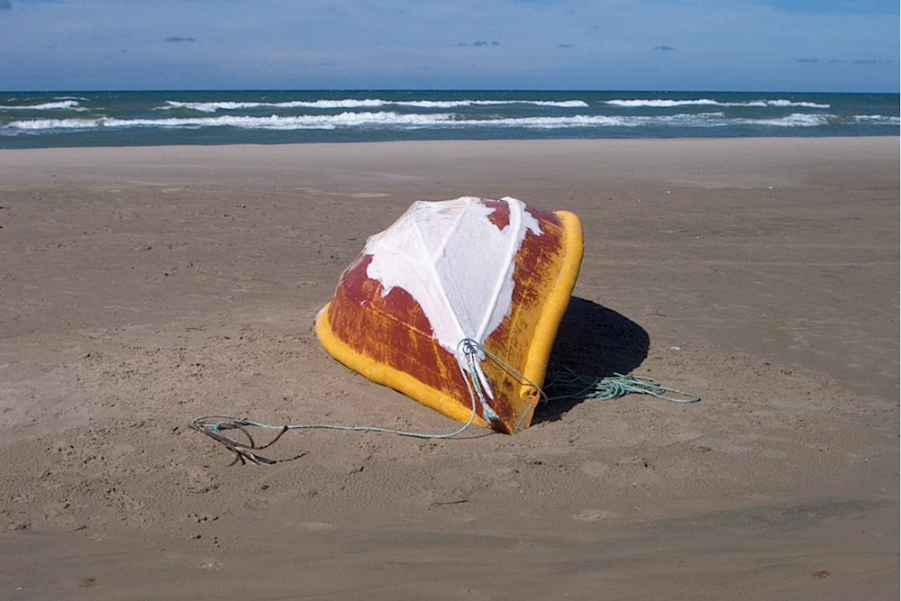 a kite sitting on top of a sandy beach