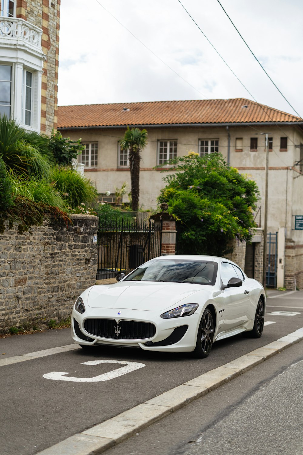 a white sports car parked on the side of the road