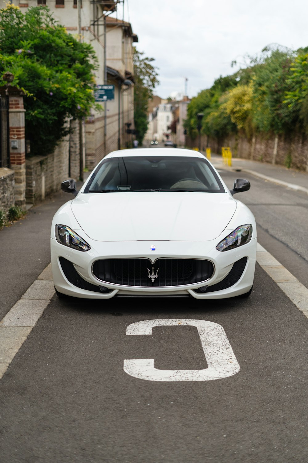 a white sports car parked on the side of the road