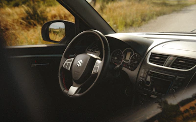 Close-up of Suzuki Jimny's allgrip pro drive selector with mountainous background.