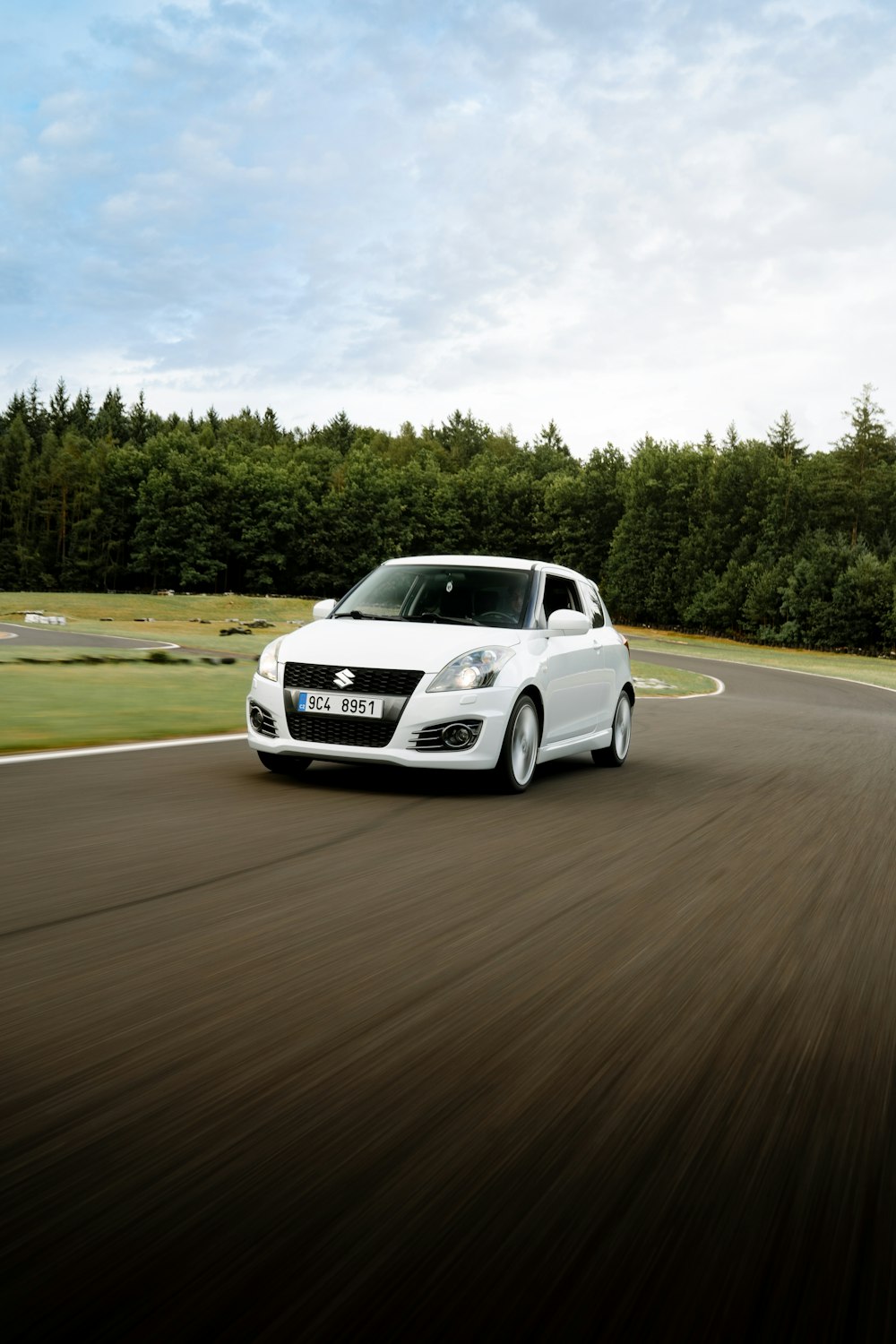 a white car driving down a winding road