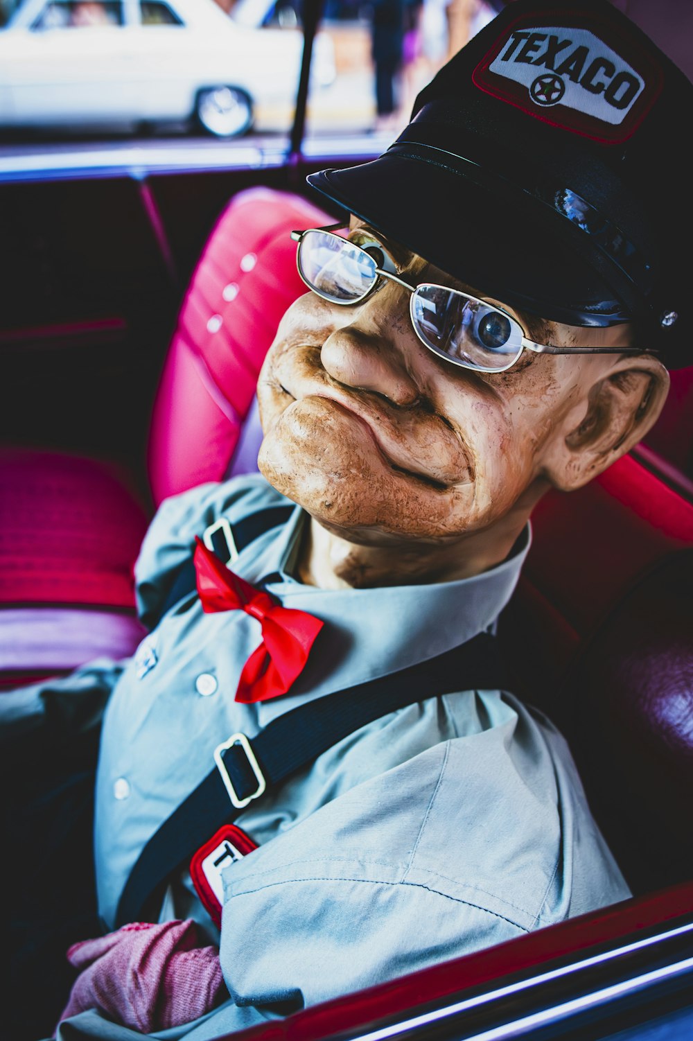 an old man in a car wearing a hat and glasses