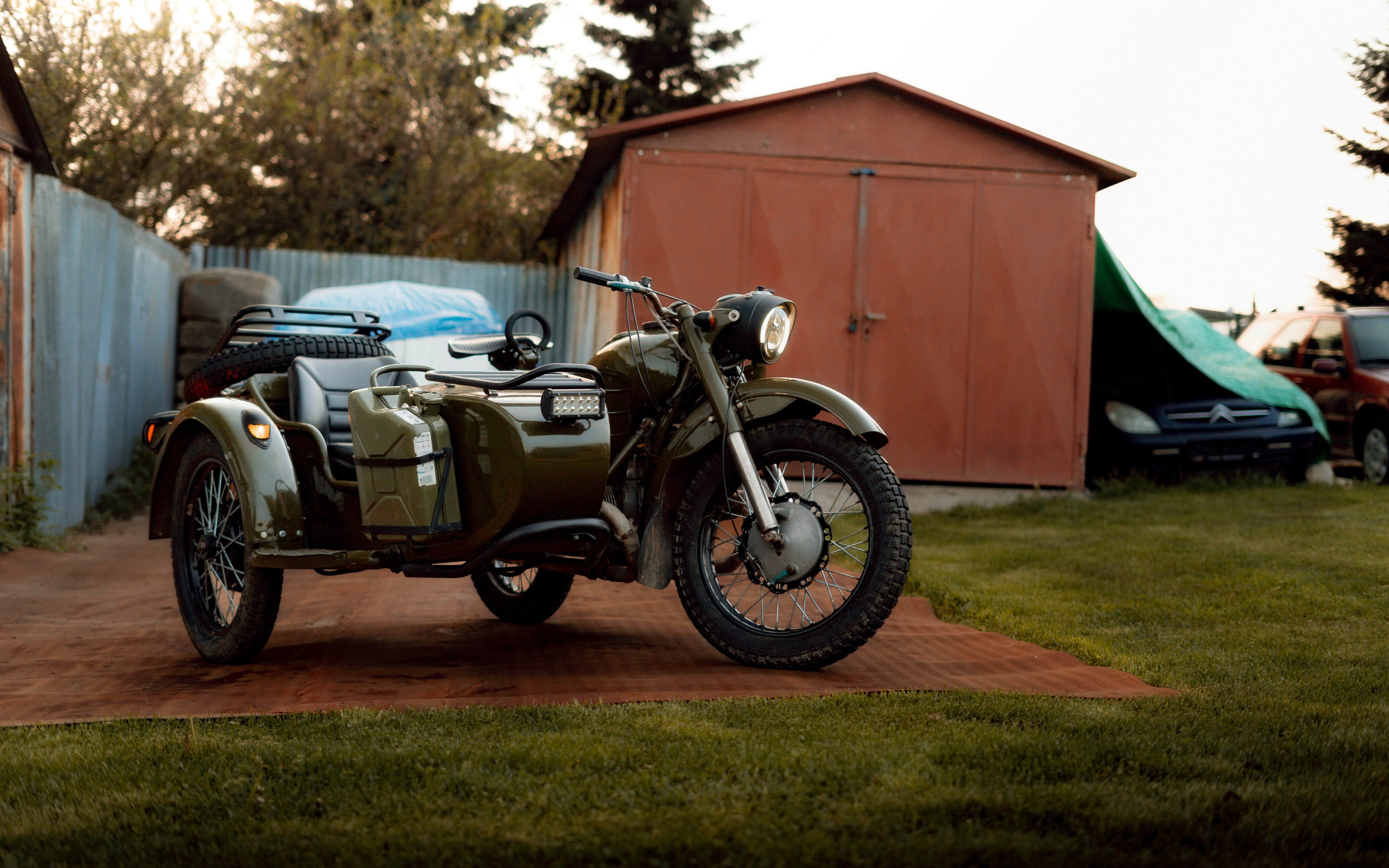 a green motorcycle parked on top of a dirt road