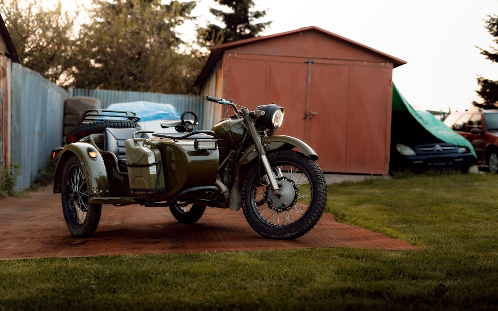 a green motorcycle parked on top of a dirt road