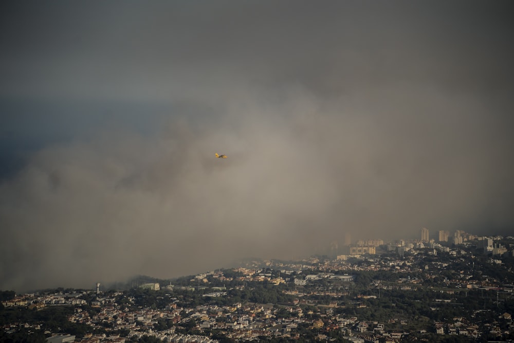 a plane flying over a city on a cloudy day
