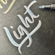 A vibrant blue pen with its cap off, ink tip shining under soft light.