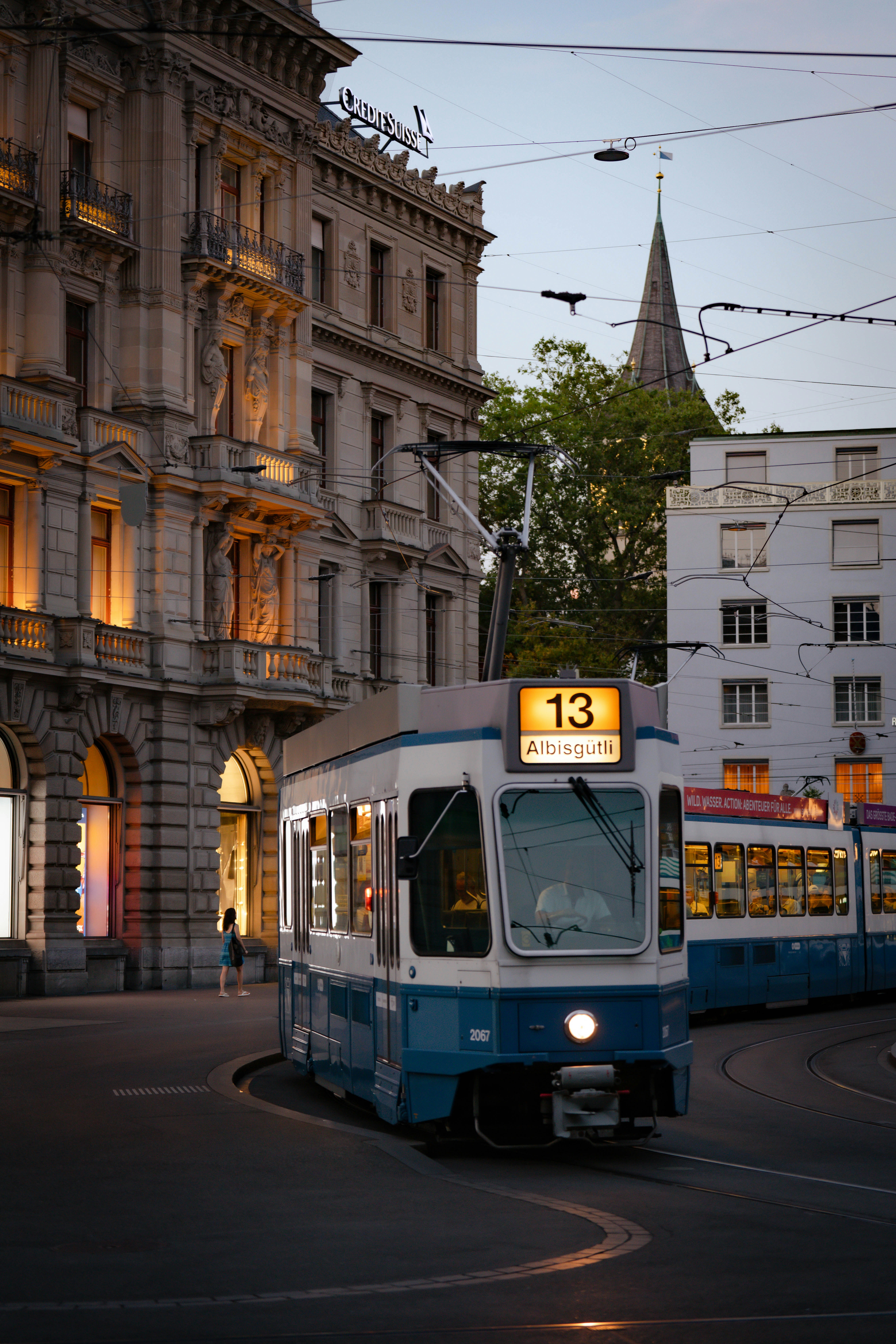 a blue and white trolley on a city street