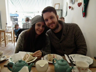A joyful couple meeting for the first time in a cozy café, smiling warmly.