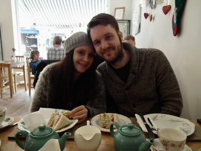 A cozy café setting where the couple is sharing a laugh over coffee.
