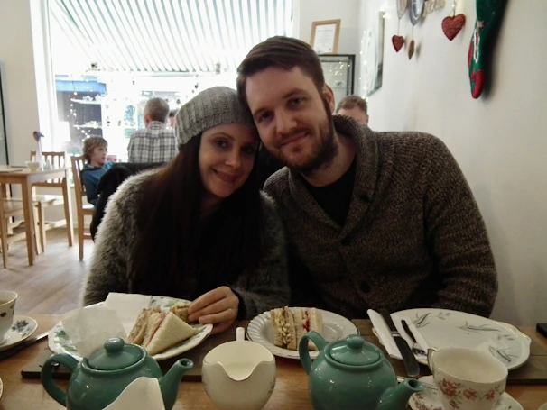 A joyful couple meeting for the first time in a cozy café, smiling warmly.