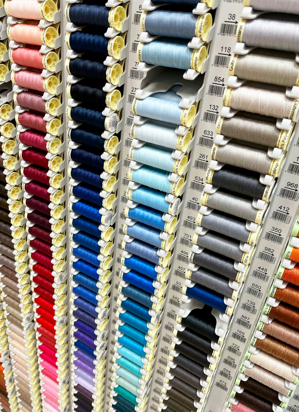 rows of spools of thread on display in a store