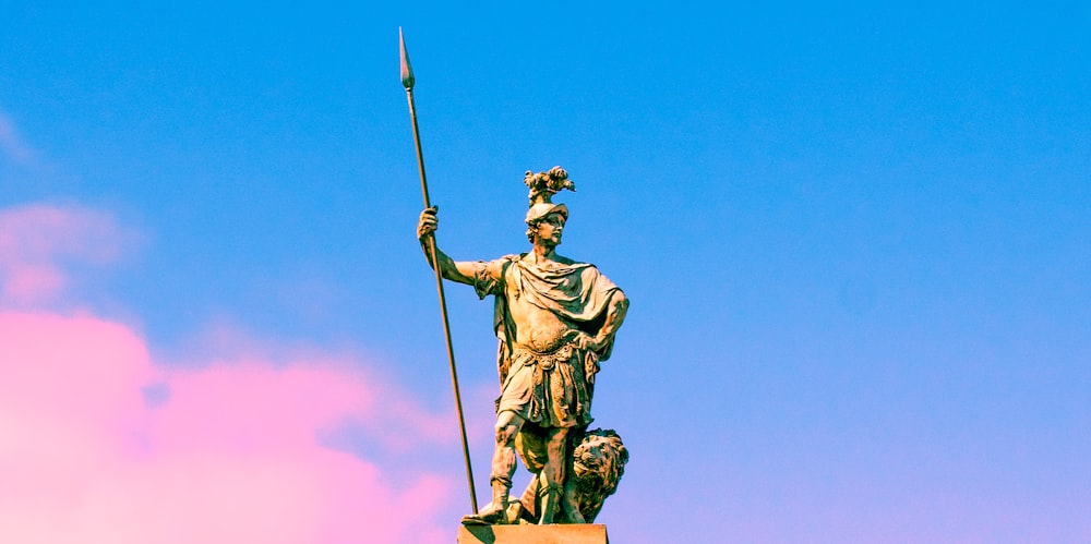 a statue of a man holding a flag on top of a building