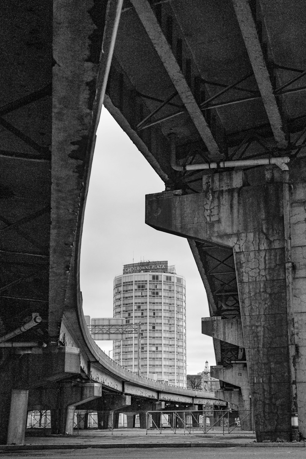 a black and white photo of a bridge with a building in the background