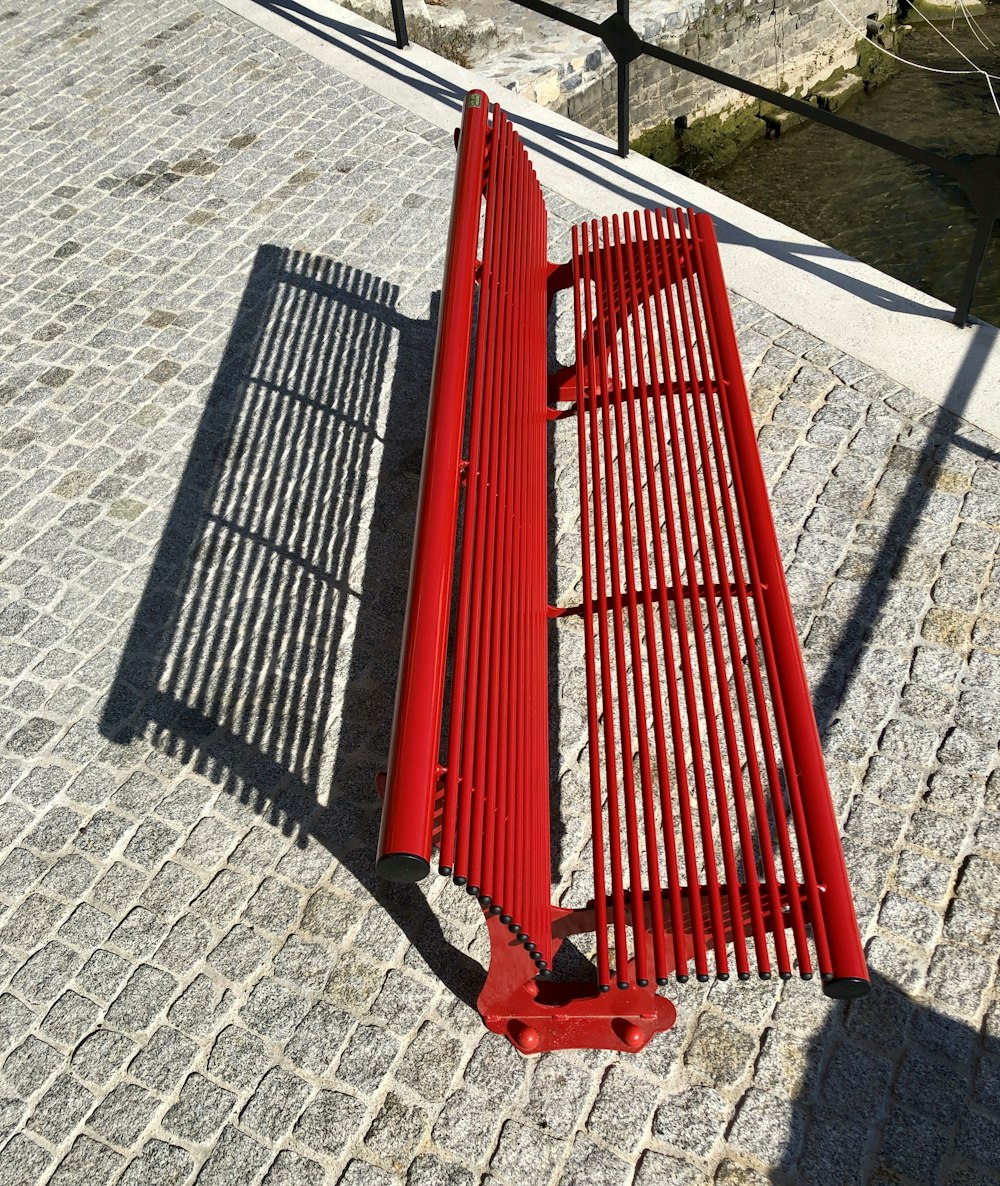 a red bench sitting on top of a brick walkway