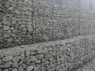 A panoramic view of a completed gabion retaining wall blending naturally with the Patagonian landscape.