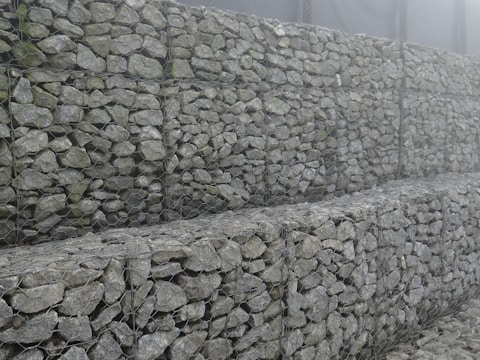 A panoramic view of a completed gabion retaining wall blending naturally with the Patagonian landscape.
