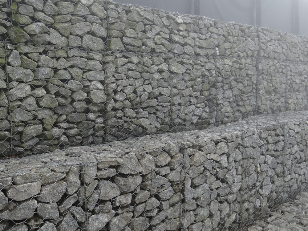 a pile of rocks sitting next to a fence