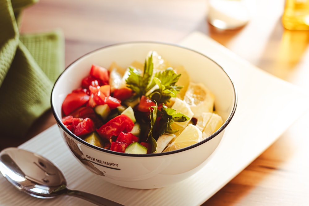 a bowl of fruit is sitting on a place mat