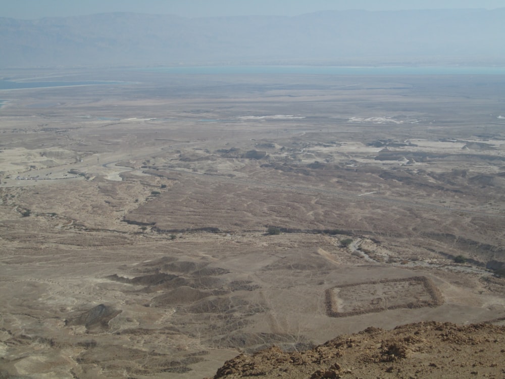 an aerial view of a desert with a square shaped building in the middle