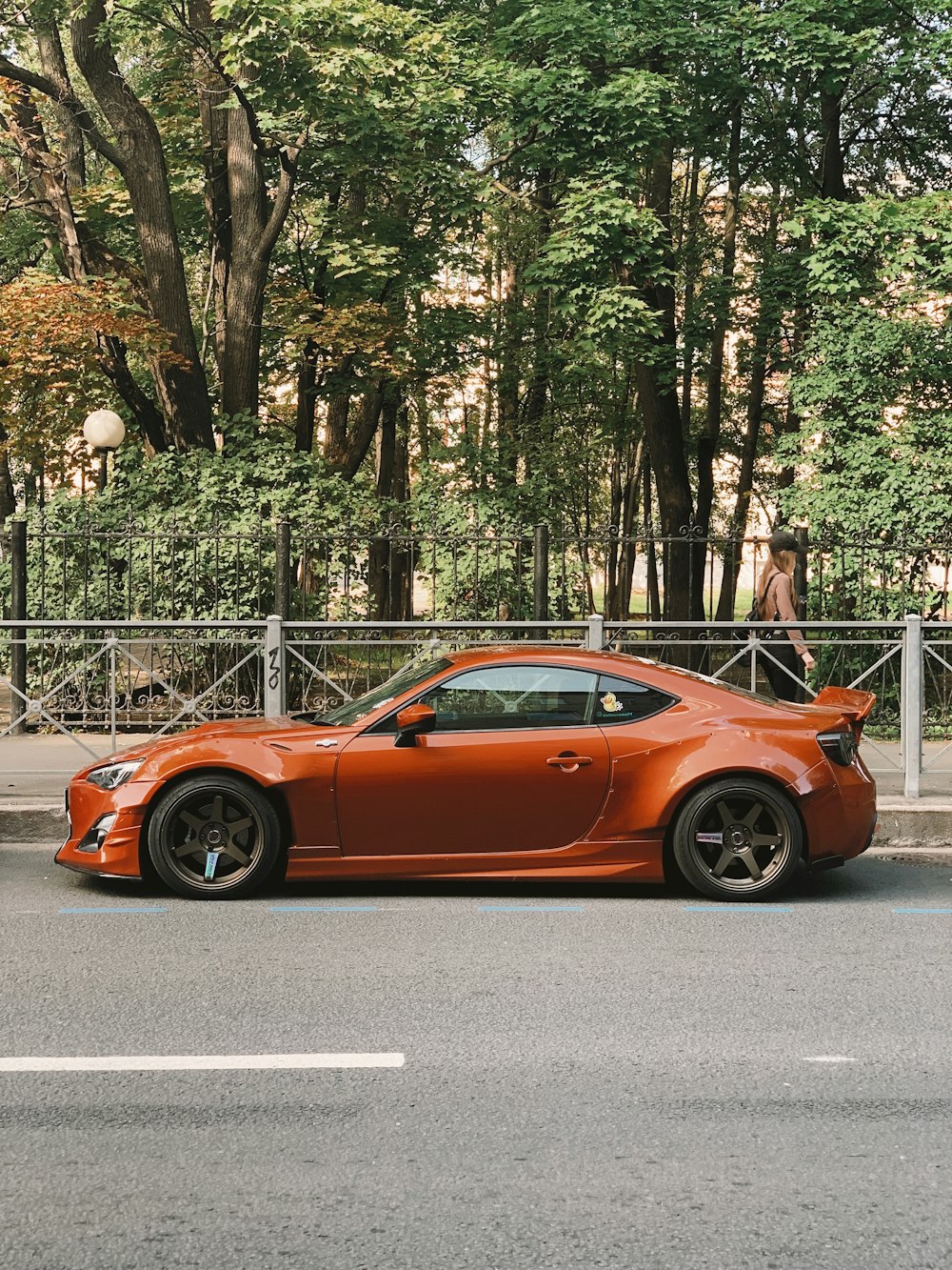 an orange sports car parked on the side of the road