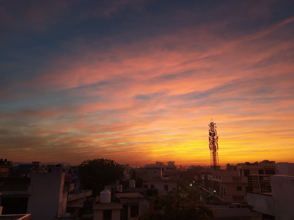 the sun is setting over a city with tall buildings