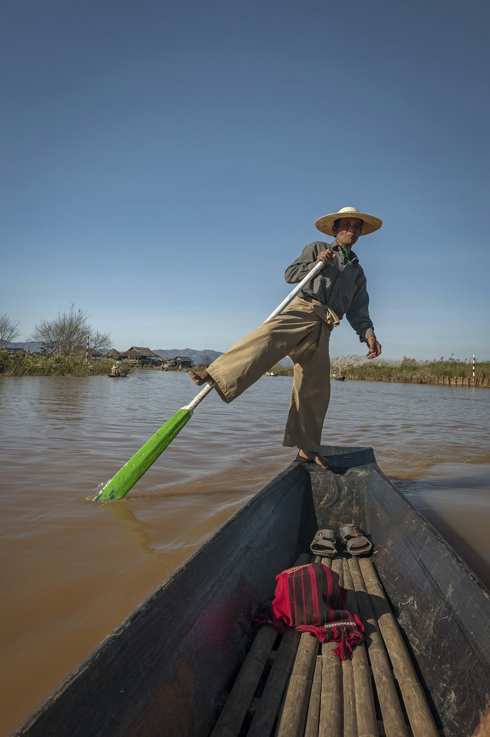 a man on a boat with a green paddle