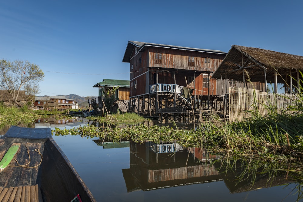 a house on stilts next to a body of water