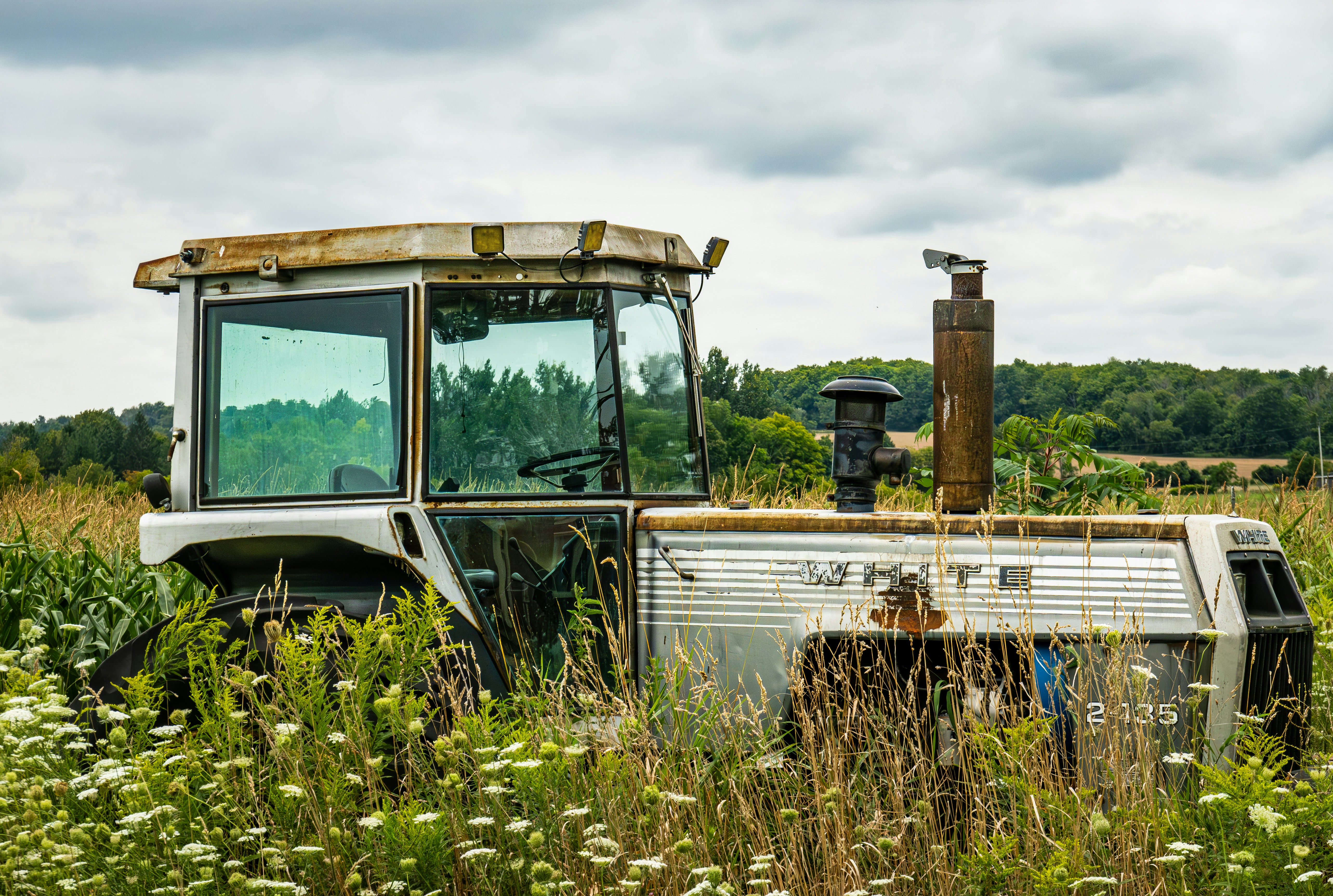 an abandoned tractor rusting away in a field