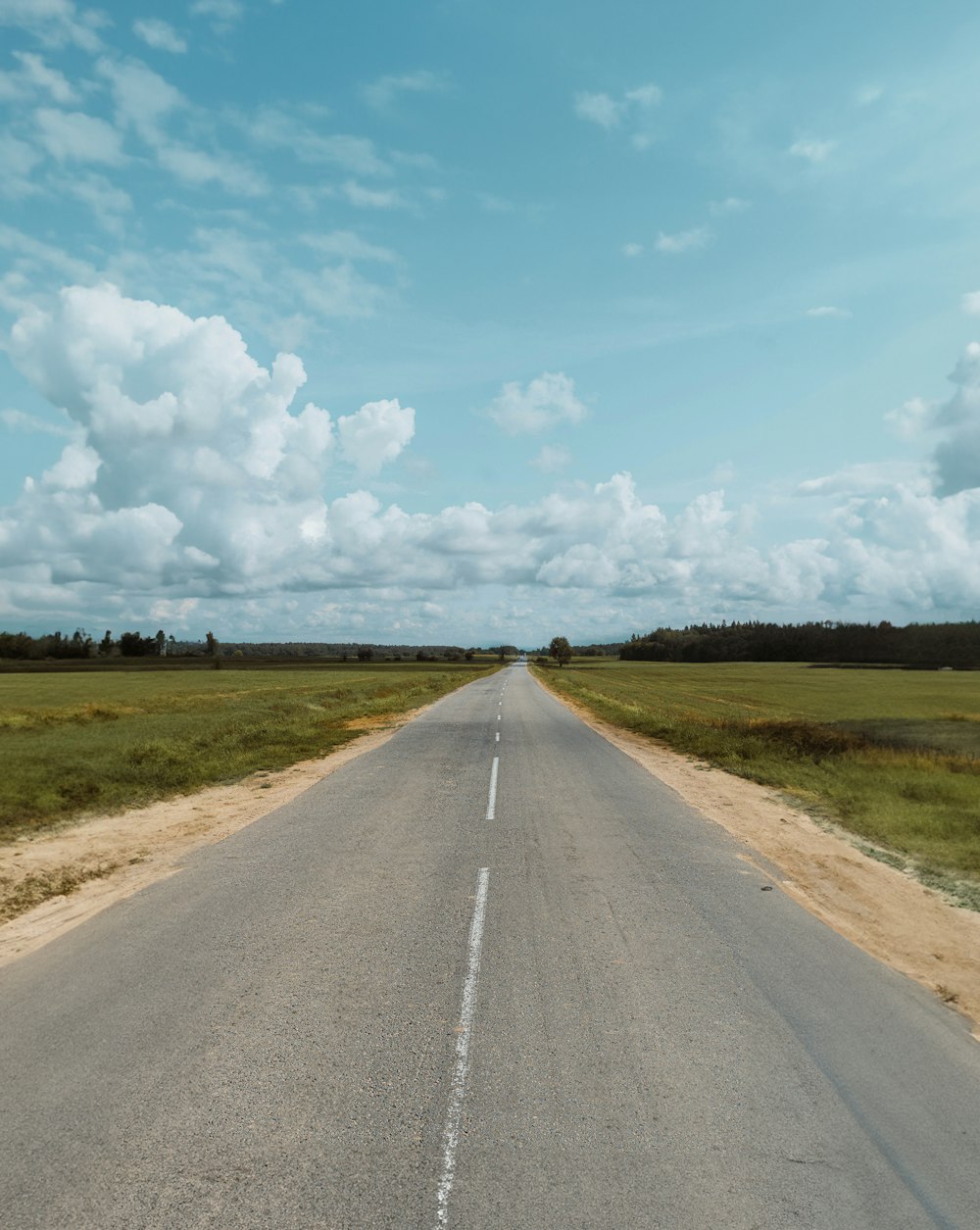 a long empty road with a sky background