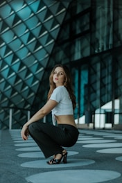 a woman kneeling down in front of a building