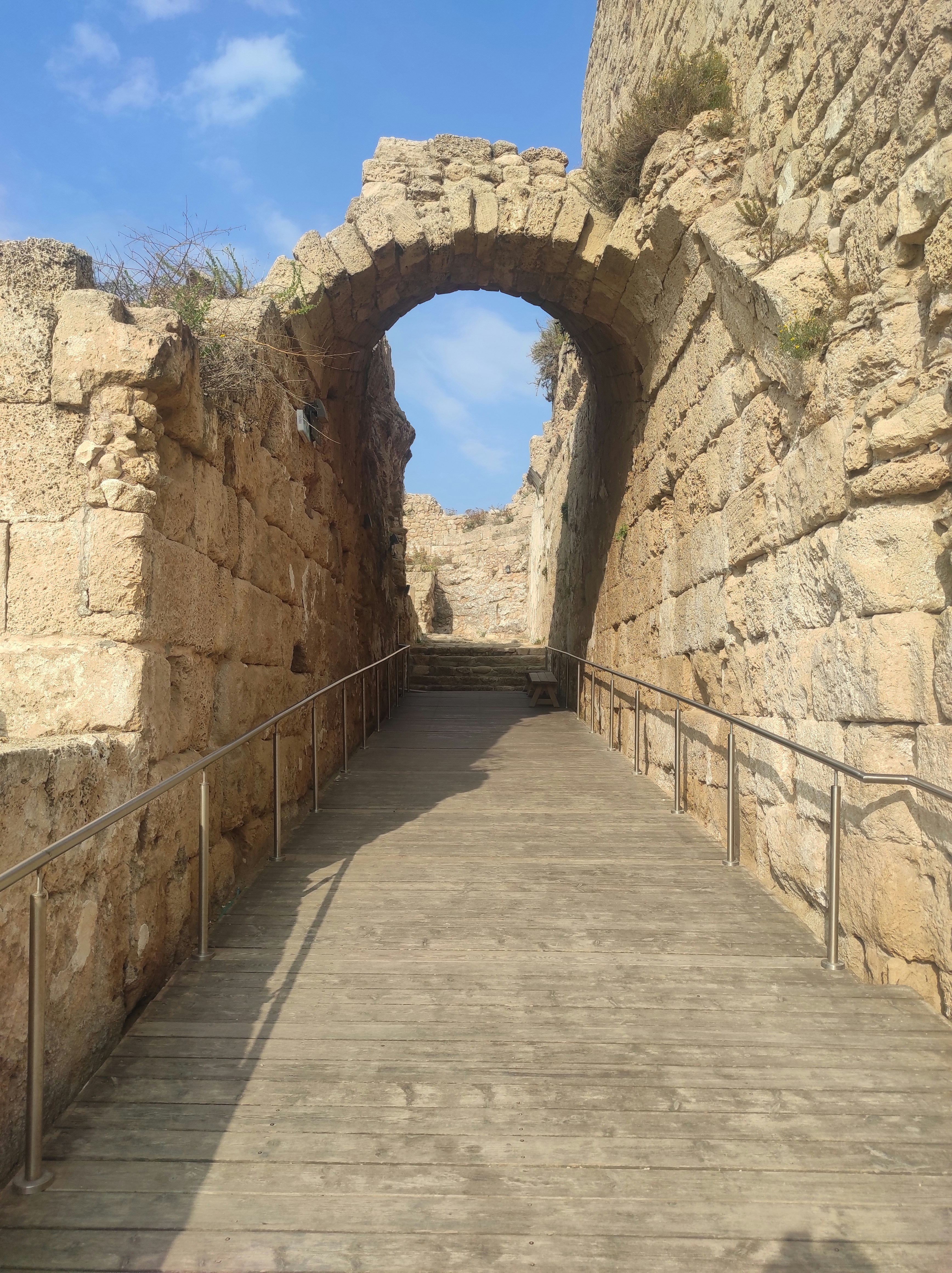 a wooden walkway going through a stone tunnel