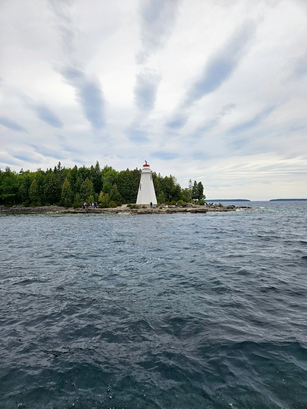 a lighthouse on a small island in the middle of the ocean