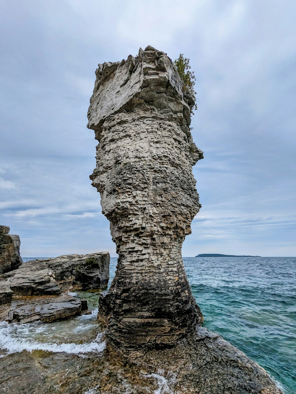 a rock formation in the middle of a body of water