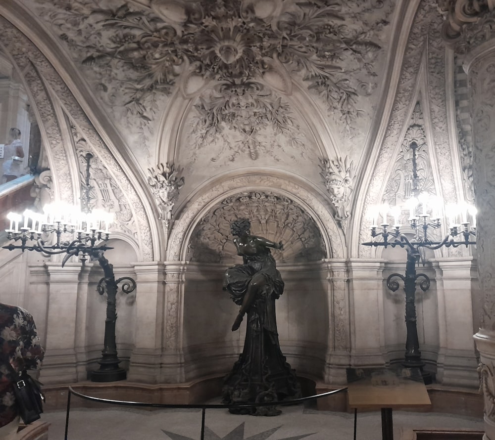 a statue of a woman in a room with chandeliers