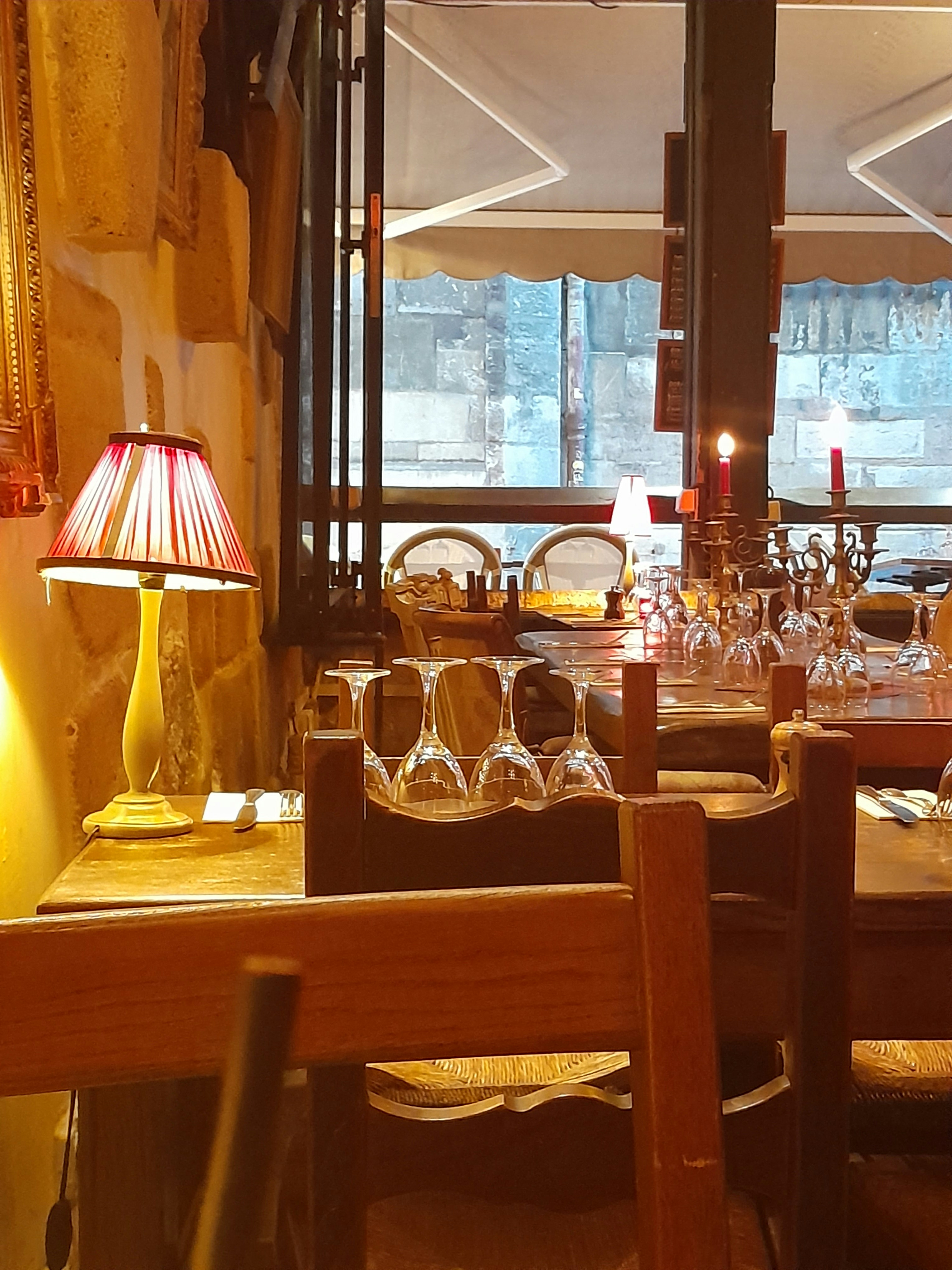 Warm restaurant dining room with wooden tables and candle lighting creating an inviting atmosphere