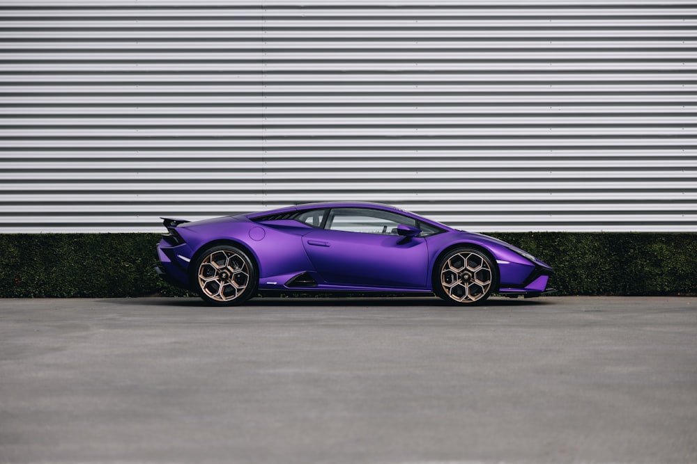 a purple sports car parked in front of a building