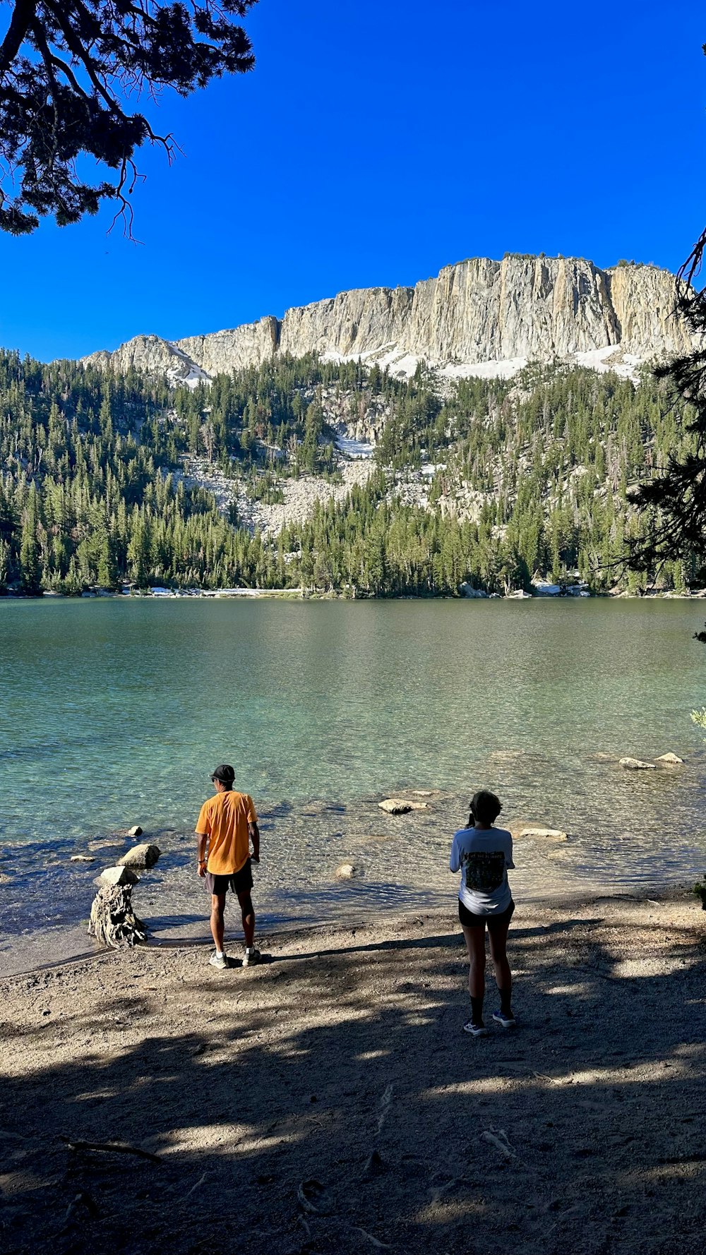 a couple of people standing next to a body of water