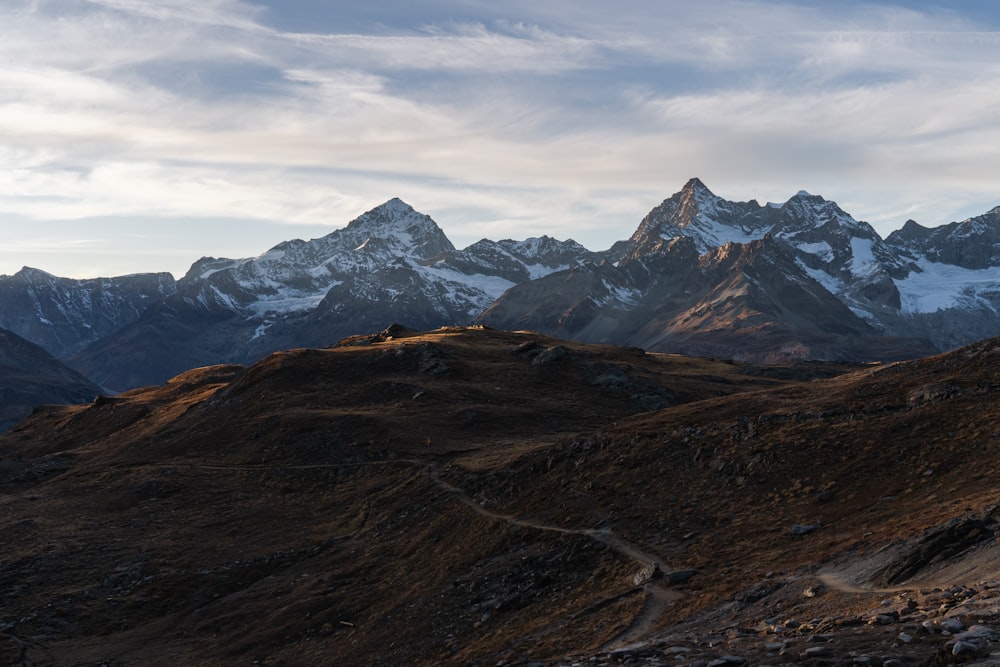 a view of a mountain range with a trail in the foreground