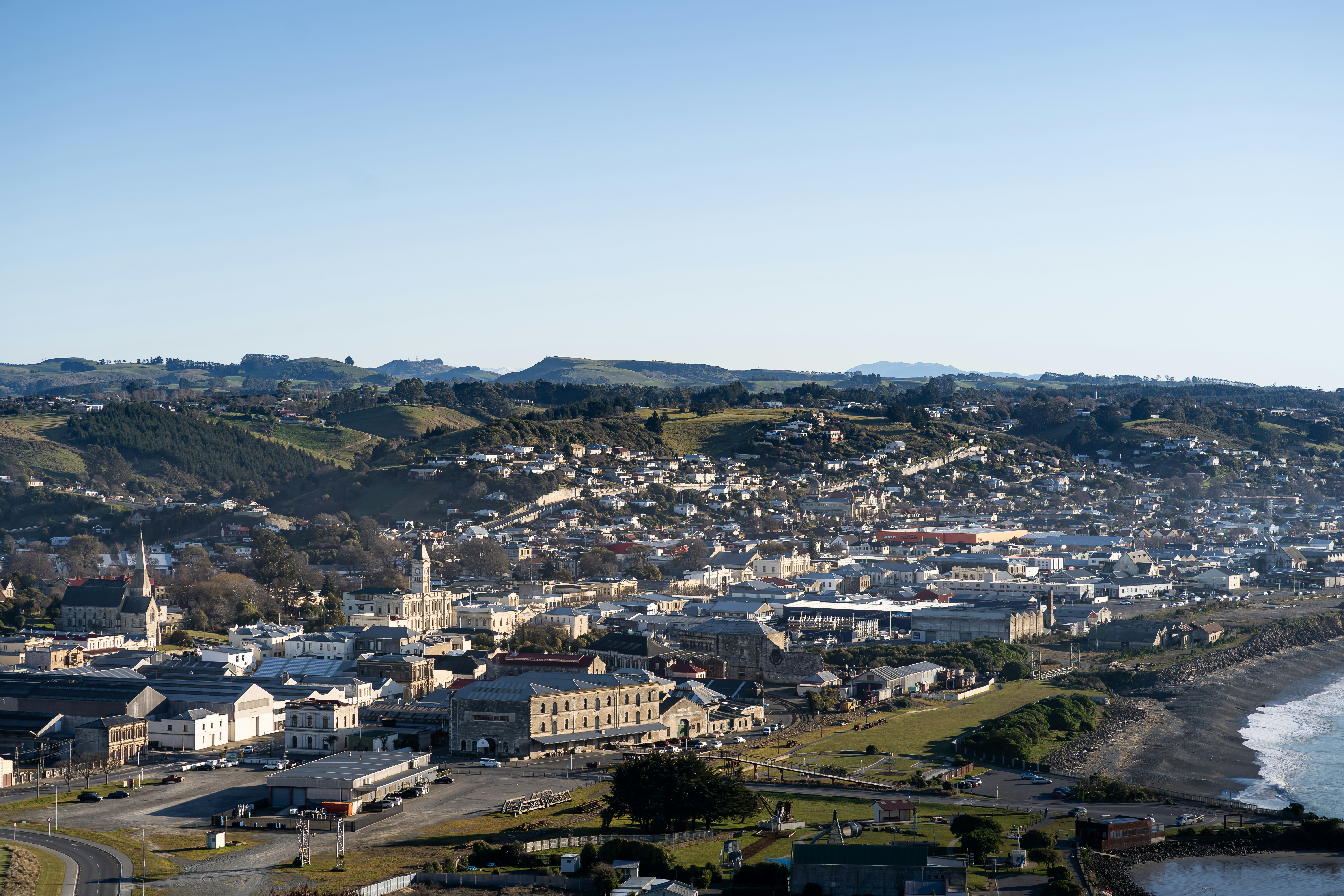 a view of a city from a hill overlooking the ocean