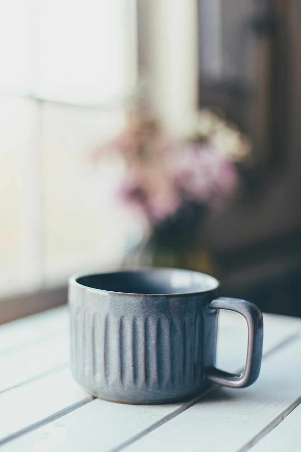 a black cup sitting on top of a white table