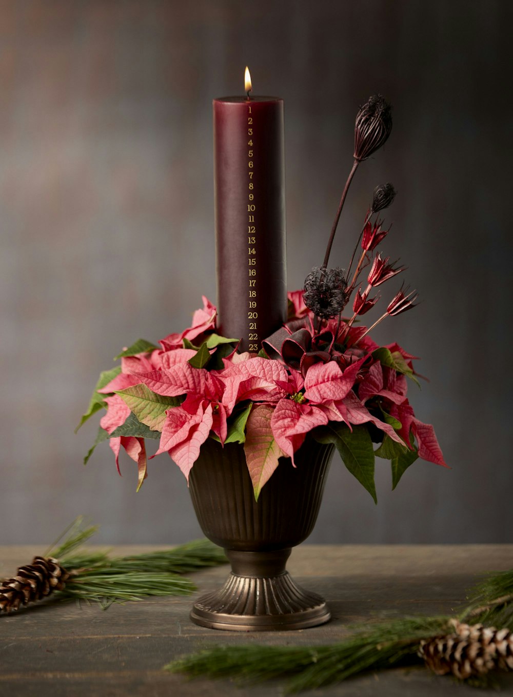 a candle and flowers in a vase on a table