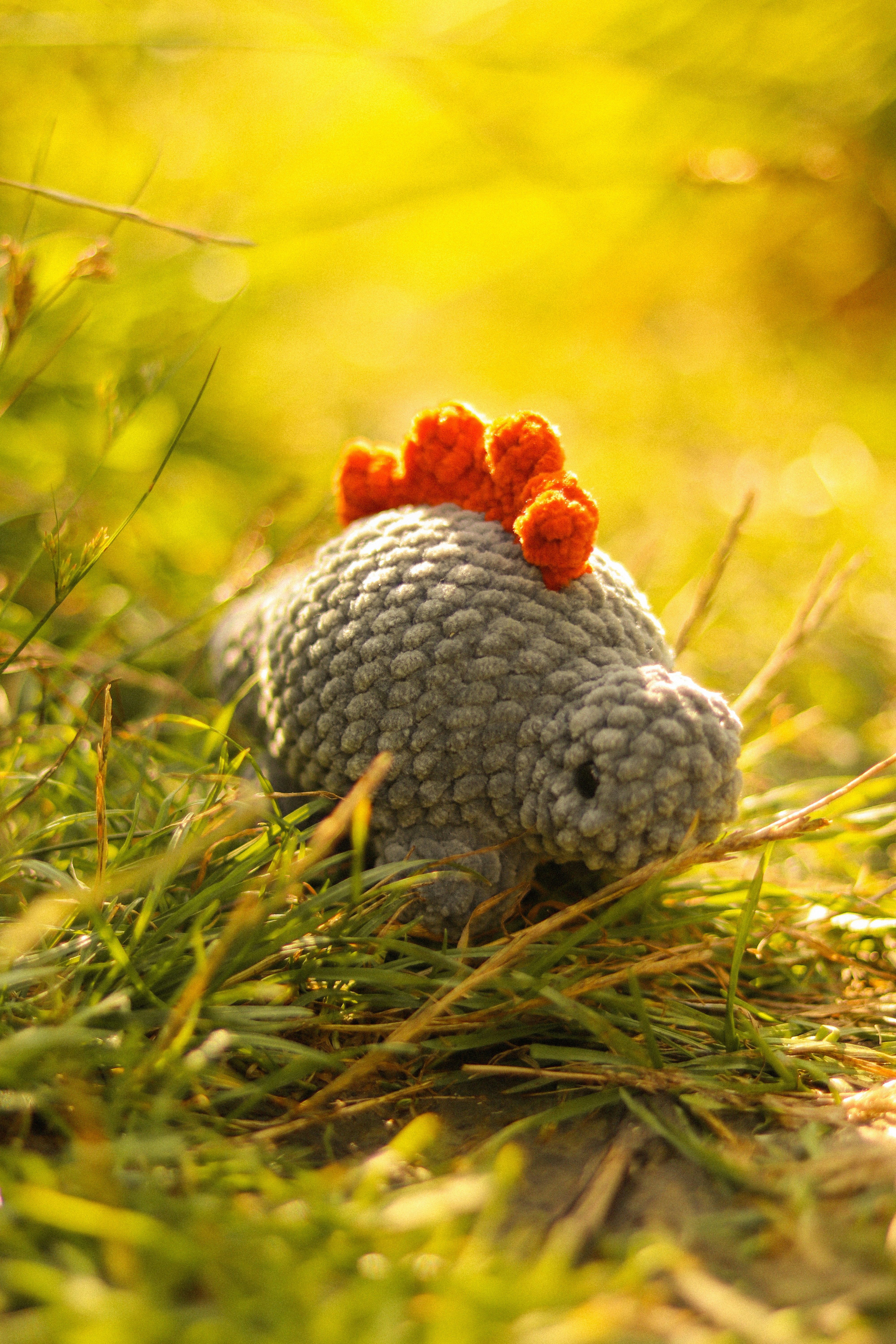 Un pequeño animal de peluche sentado en la hierba