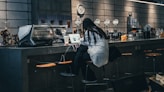 a woman sitting at a bar with a laptop