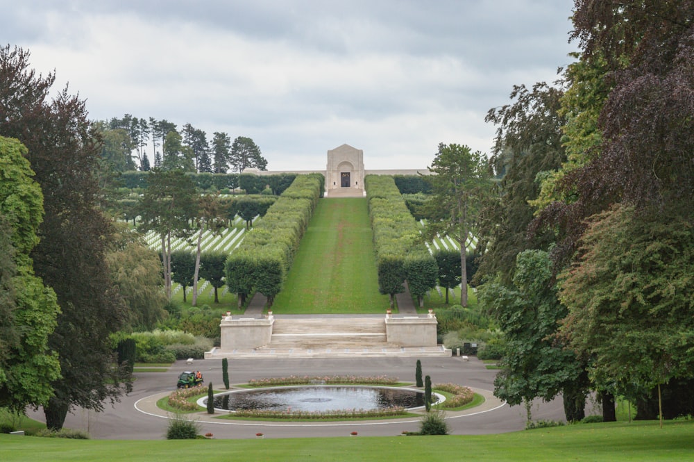 a view of a garden with a fountain surrounded by trees