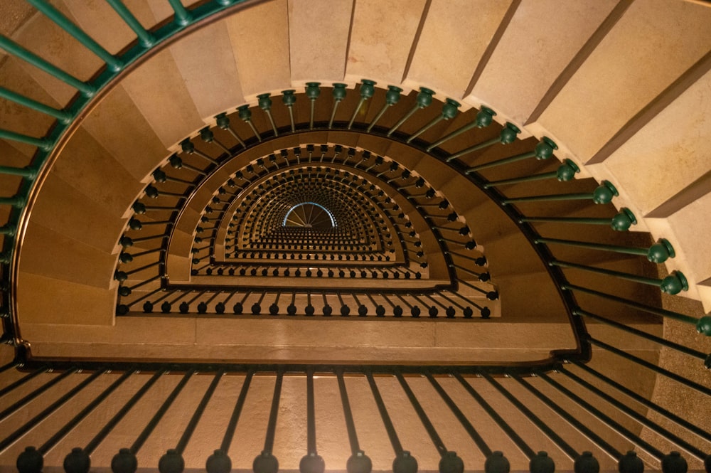 a spiral staircase in a building with green railings