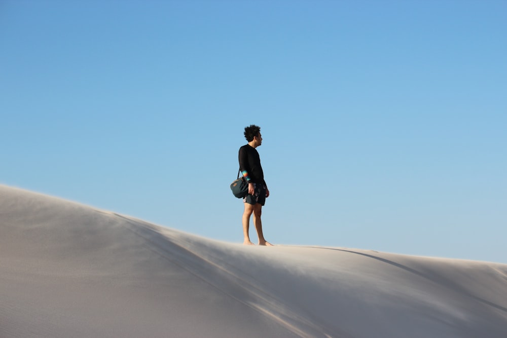 a person standing on top of a sand dune