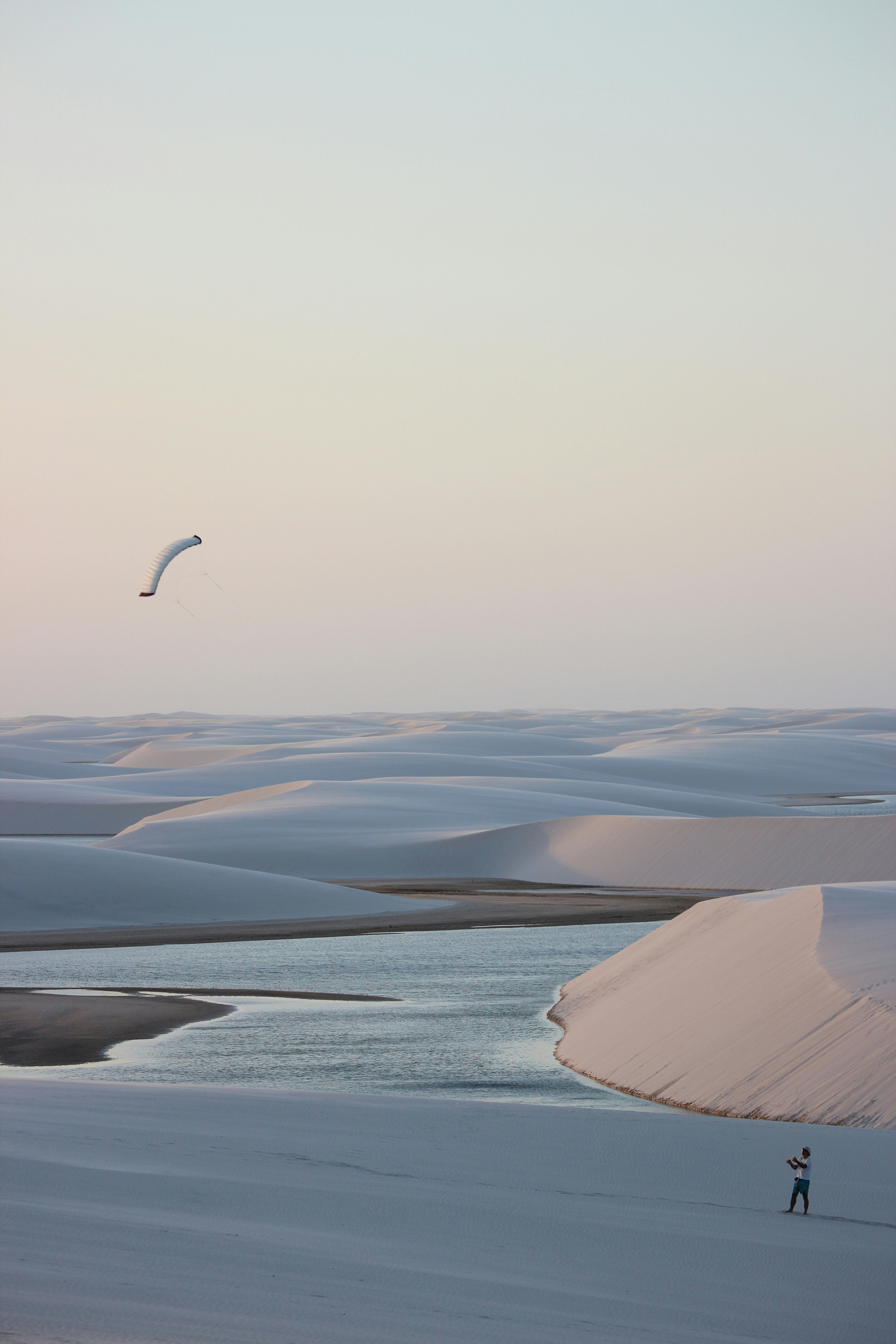a person flying a kite in the middle of a desert
