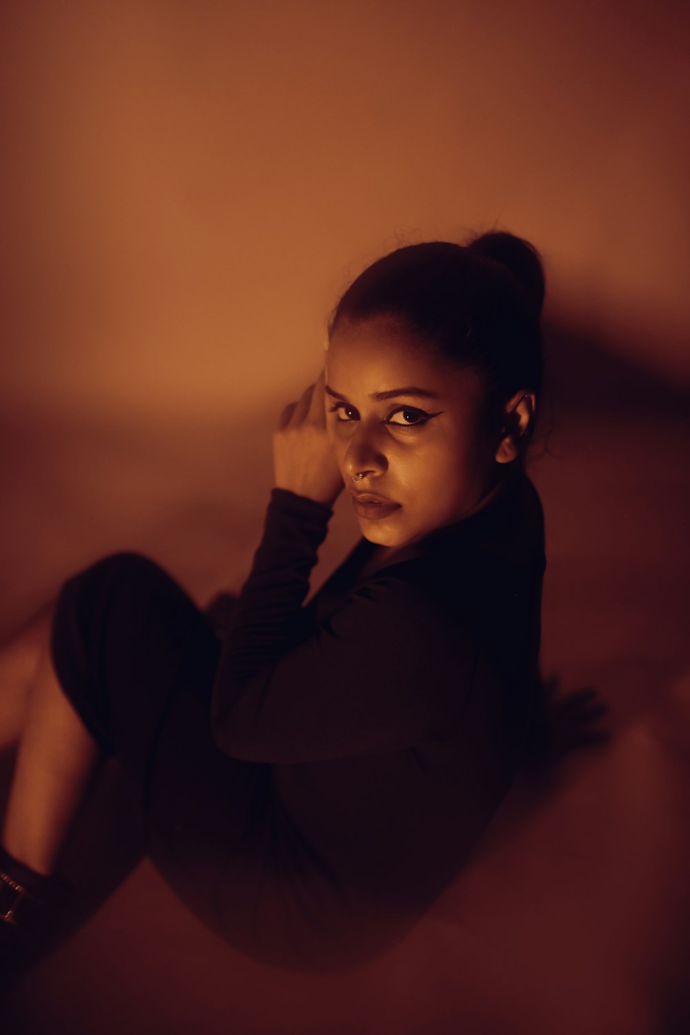 a woman sitting on the floor in a dark room