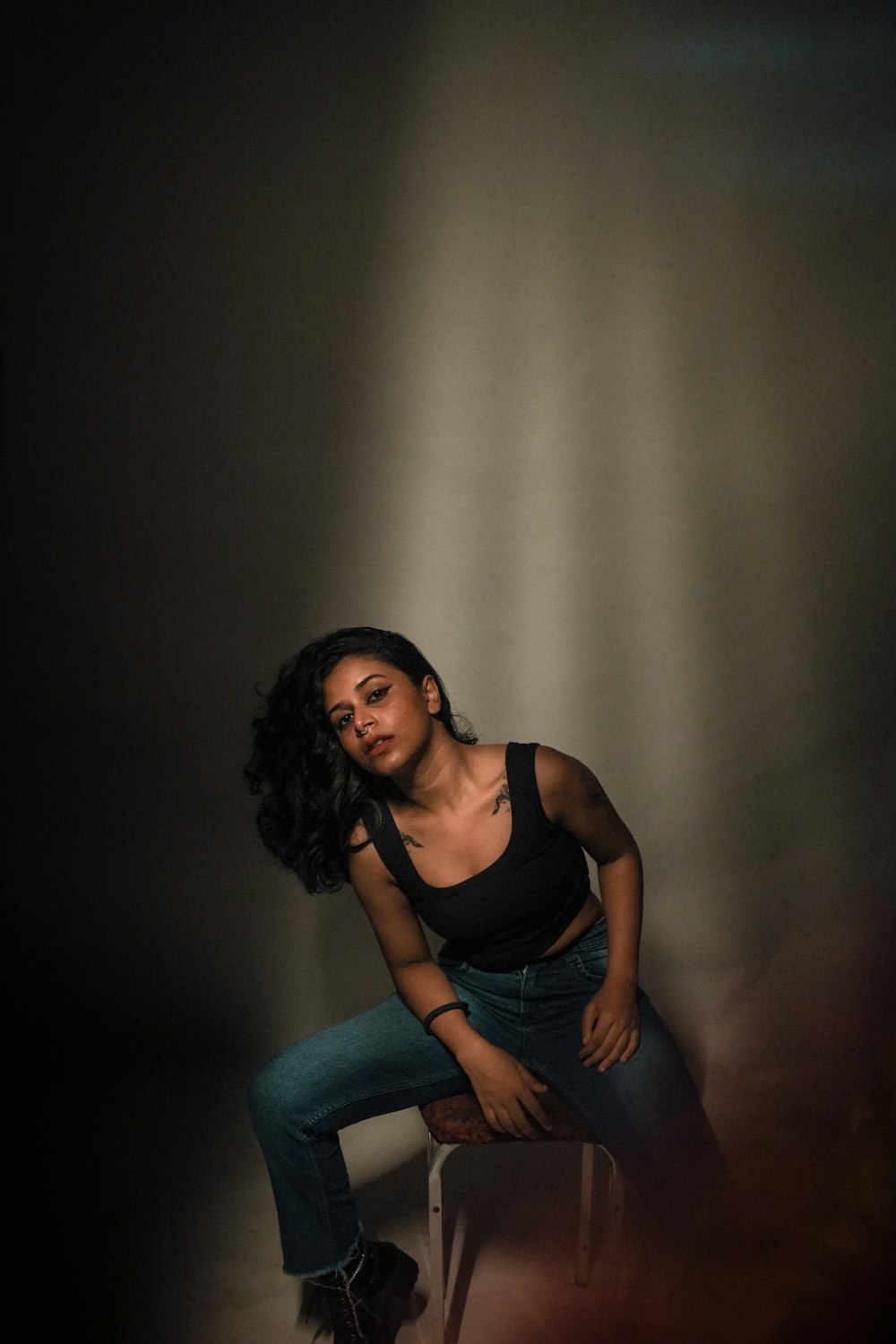 a woman sitting on a chair in a dark room